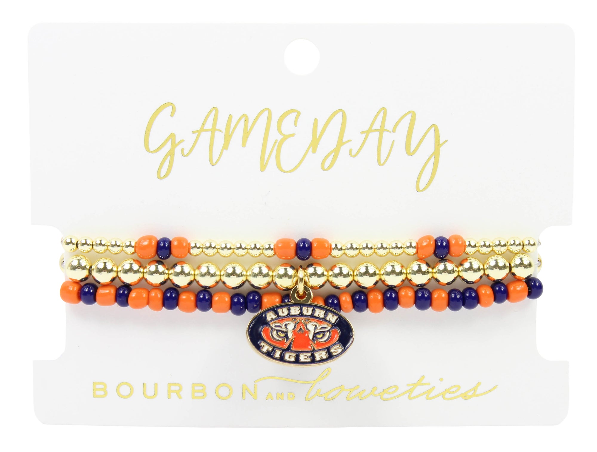 A set of three beaded stretch bracelets displayed on a white branded card. The bracelets feature gold-tone beads, orange and navy blue beads, and a central oval charm with the Auburn Tigers logo.