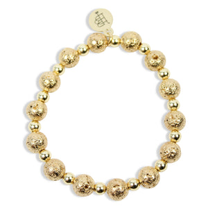 Annie Gold Lava Stretch Bracelet featuring textured gold lava beads, polished gold spacer beads, and signature gold tag by Bourbon and Boweties