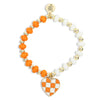 Orange and white beaded stretch bracelet with gold accents and an orange and white checkered heart charm by Bourbon and Boweties.